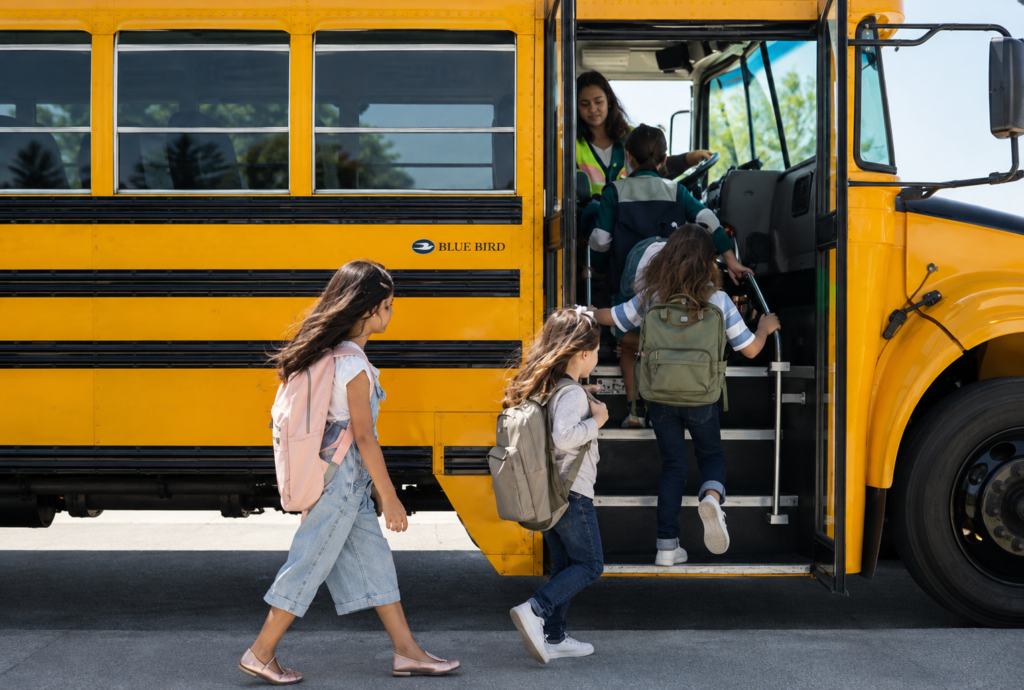 Students boarding a Blue Bird school bus for school transportation