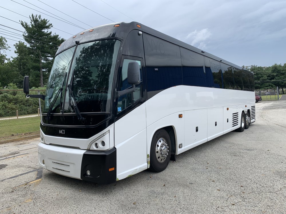 White MCI coach bus parked on a New York City street.