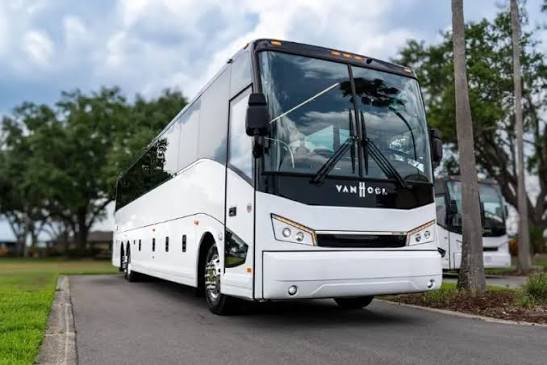 White VanHool coach bus parked on a New York City street.